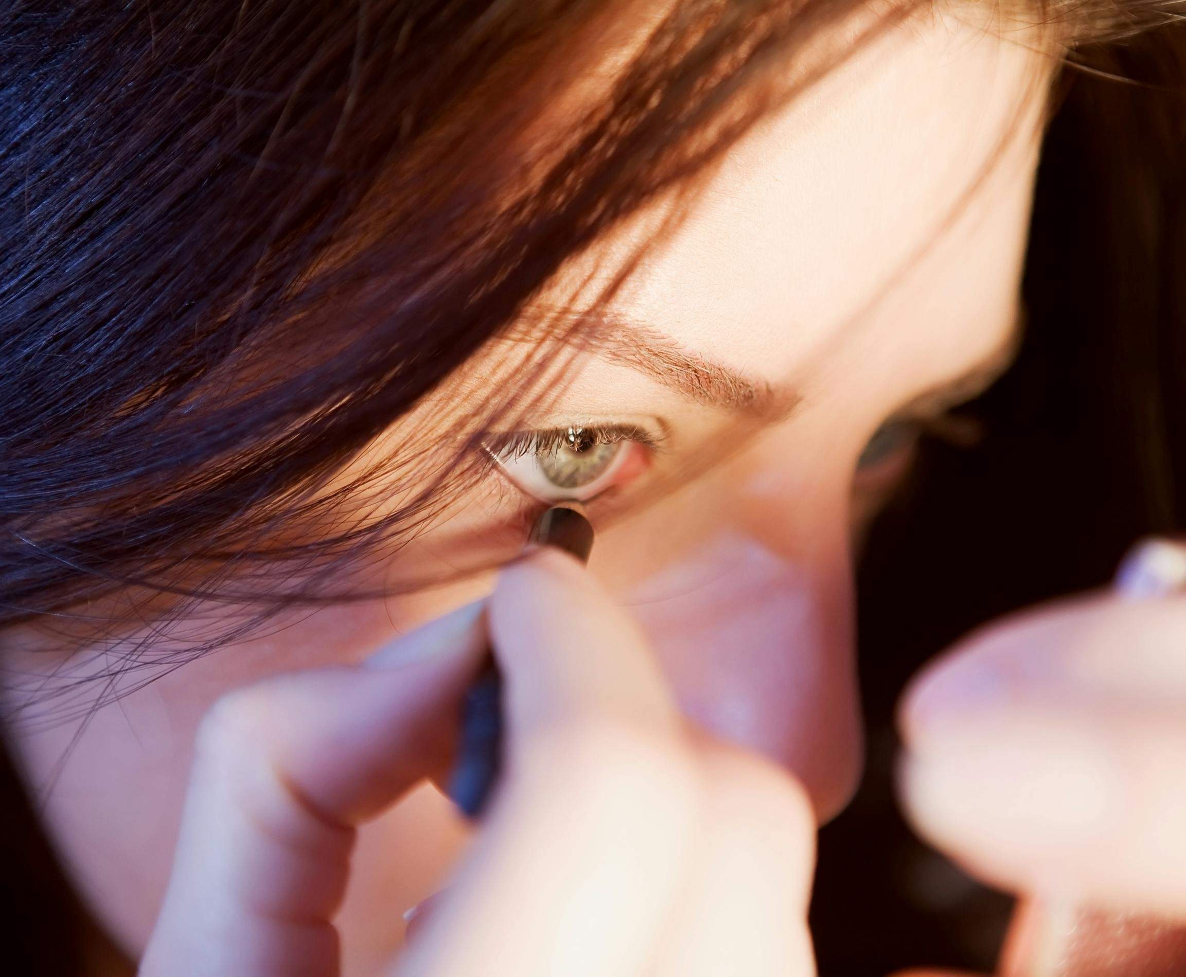 Close-up shot of a hand applying makeup primer evenly across the face