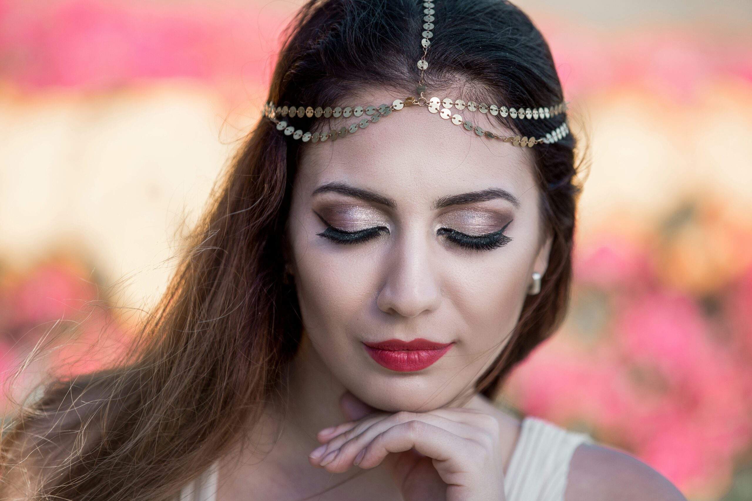 A high school student posing confidently in elegant prom makeup.