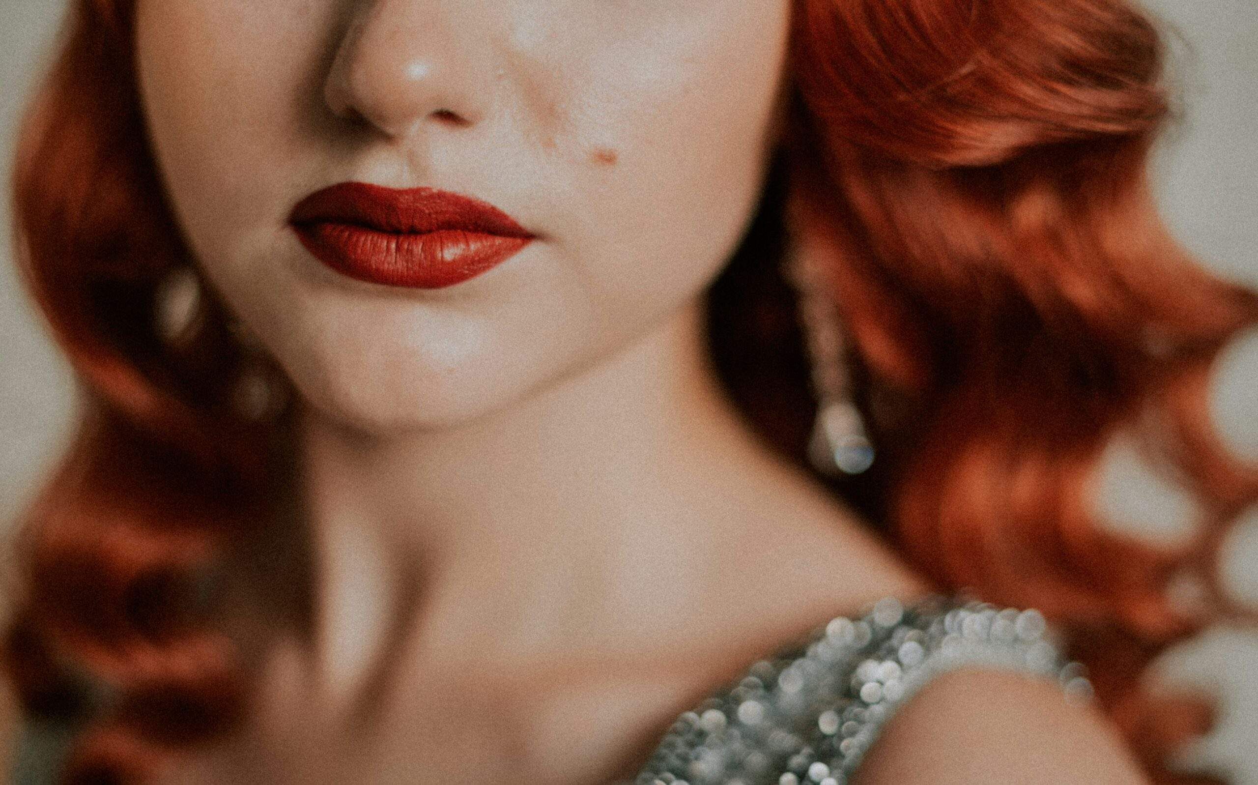 Close-up of model wearing bold smoky eyes and glossy lips