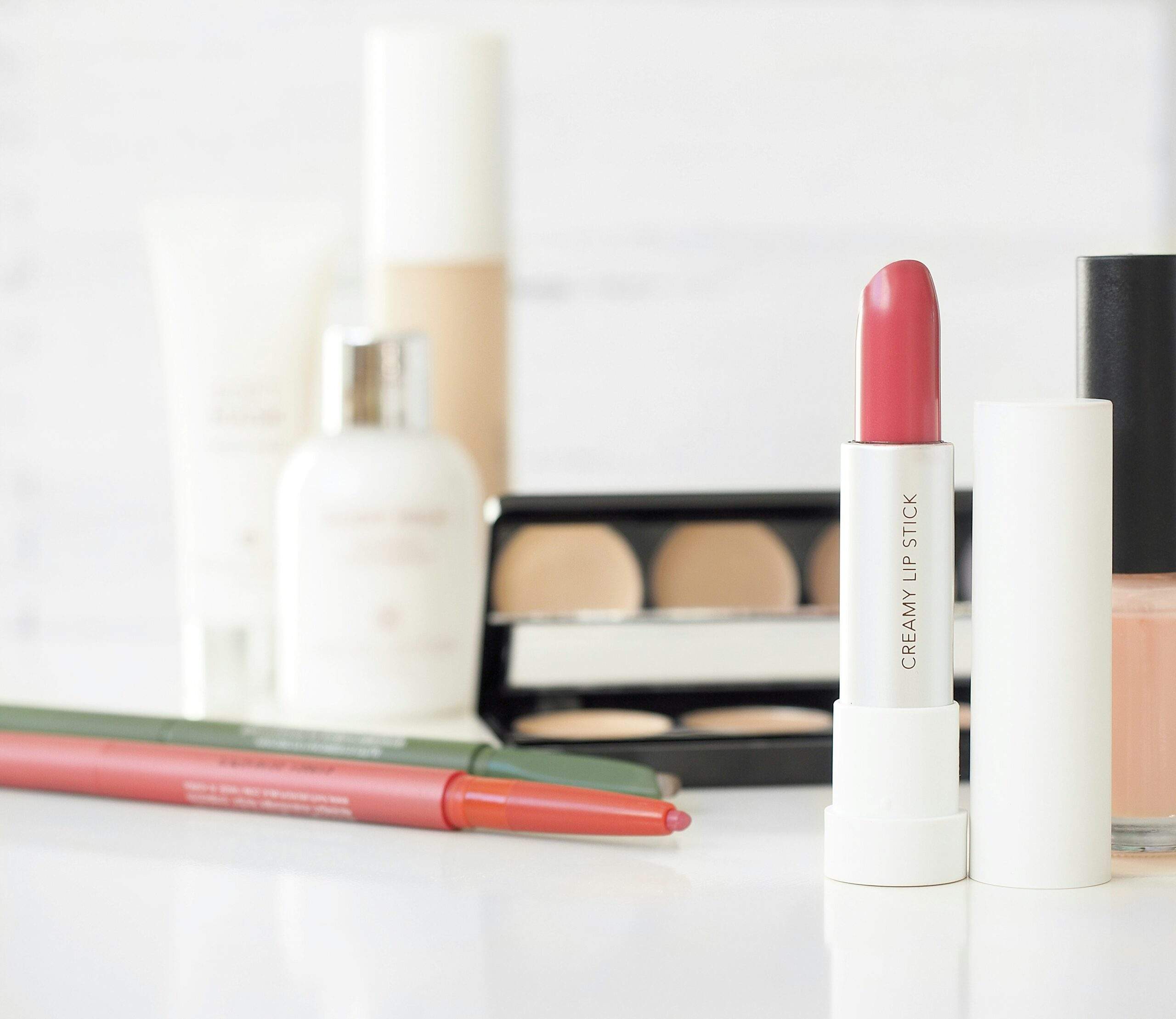 Collection of prom makeup products including foundation, brushes, and eyeshadows arranged neatly.