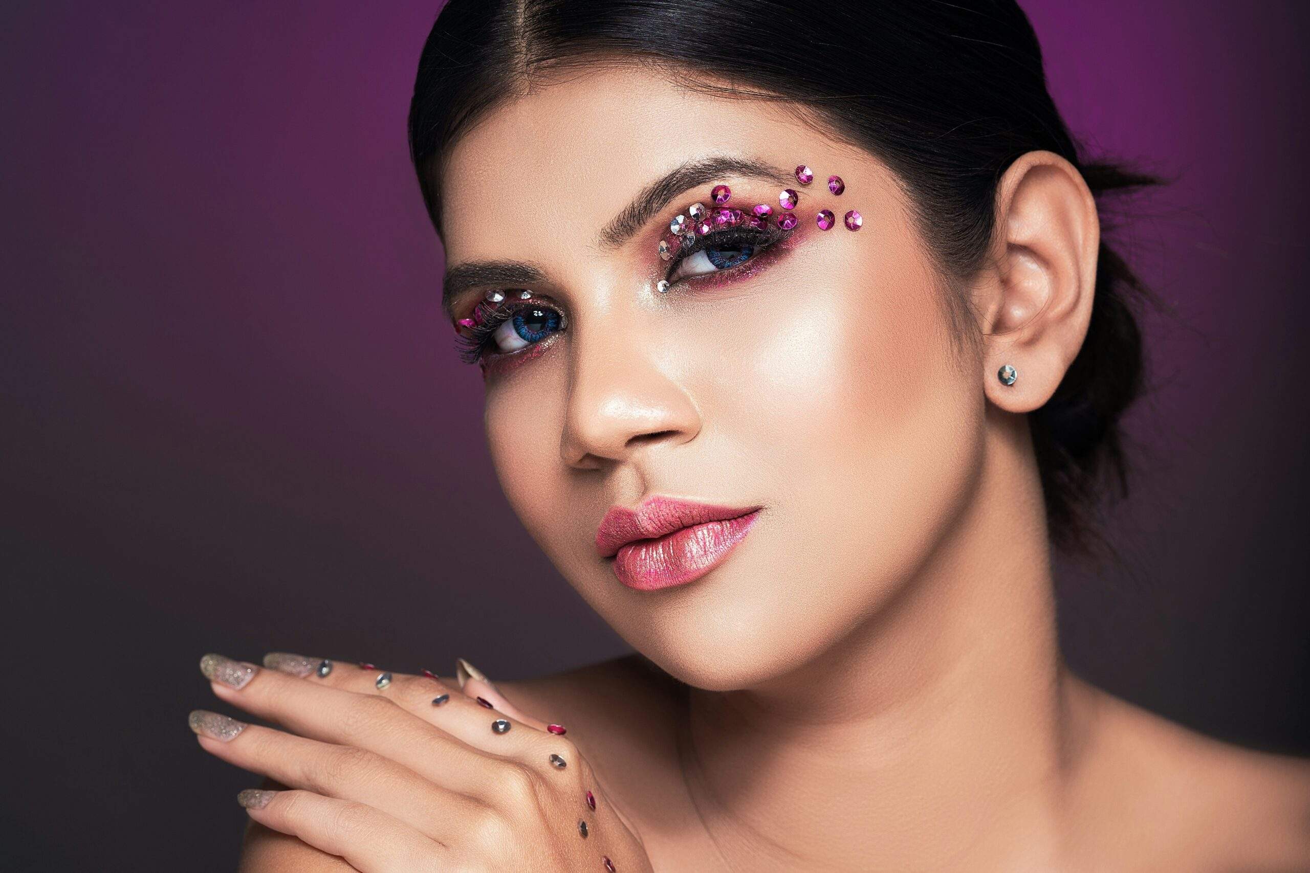 Young woman smiling confidently with elegant makeup highlighting her features.